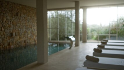 Interior of a tranquil spa with blurred background, featuring elegant chaise lounges and a serene...