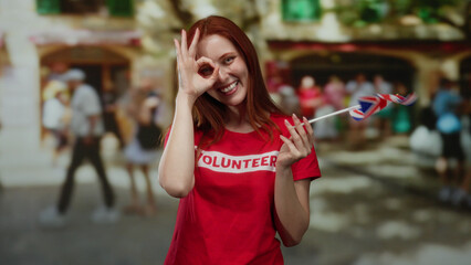 Woman smiling with british flag outdoors showcasing volunteer spirit in a lively city street while...