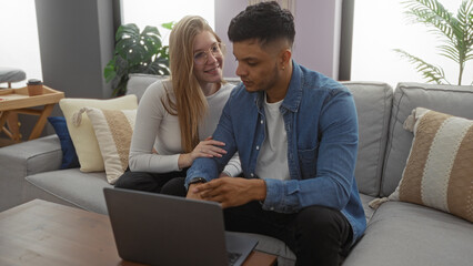 Couple sitting together in a cozy living room with a laptop, showcasing a loving relationship in a modern home interior.