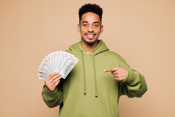 Young man of African American ethnicity wear green hoodie casual clothes hold point finger on fan...