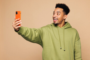Young man of African American ethnicity wear green hoodie casual clothes doing selfie shot on...