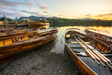 Wooden boats with beautiful summer sunset at Derwentwater in The Lake District, UK.