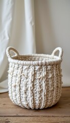 Fototapeta premium Cream Colored Knitted Rope Basket on Wooden Surface