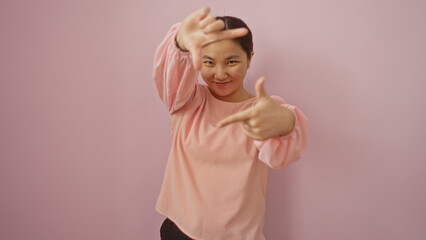 Woman posing playfully against a pink background, featuring a young, attractive, chinese, female...