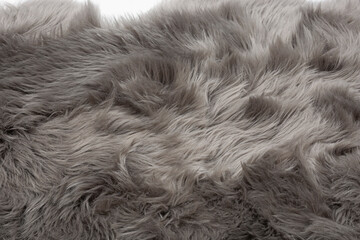 Gray fur texture as a background for designers. Gray faux fur with long hairs