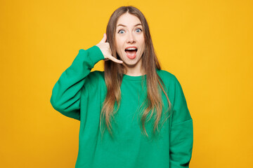 Young shocked surprised Caucasian woman she wear green sweatshirt casual clothes do phone gesture...
