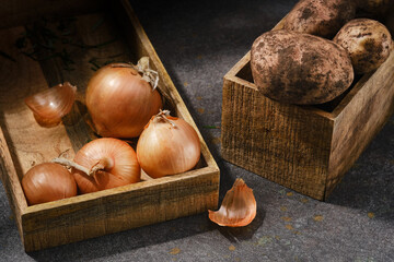 Onions and potatoes  in wooden boxes. The harvest is in boxes.Shallow depth of field