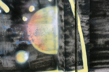 Black, gray letters with red, yellow, and orange spheres, thick lines with red borders, black spheres. A drawing, graffiti depicting word OBM is applied to a gray, brown concrete fence.