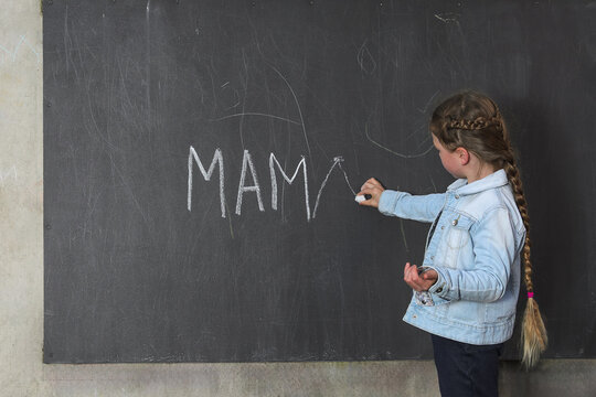Girl Writes Mama on Chalkboard Learning.