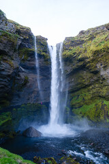 Majestic Kvernufoss waterfall cascading in the scenic landscape of Iceland