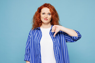 Young sad disappointed ginger woman she wears shirt t-shirt casual clothes show thumb down gesture...