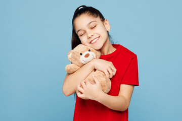 Little kid girl 8-9 years old wears red t-shirt have fun hold in hand hug teddy bear isolated on...