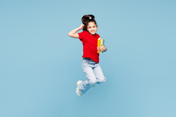 Full body little smart happy child kid girl 8-9 years old wears red t-shirt have fun holding read...