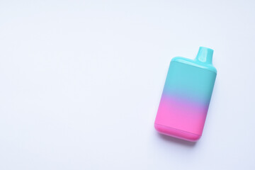 There is one multi-colored electronic cigarette on the light table. A vape with nicotine. Copy space