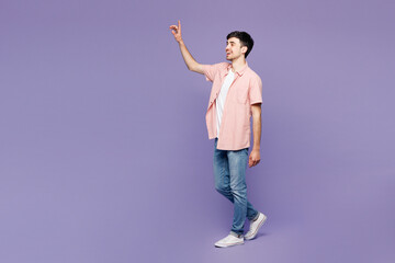 Full body side profile view young smiling happy man he wears pink shirt t-shirt casual clothes walk...