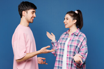 Side view young couple two friends family man woman wear pink casual clothes together look to each...