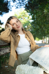 Beautiful and young blond woman portrait reading a newspaper in the park