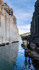 Exploring the breathtaking cliffs of Studlagil Canyon in Iceland during a sunny day