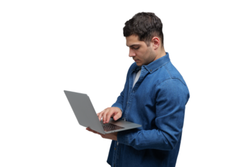 Focused young man engages with laptop, immersed in work, highlighting modern tech usage in everyday life