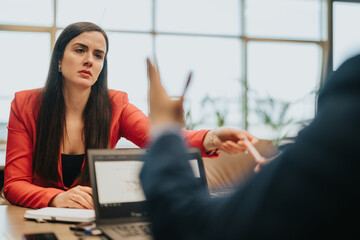 Two business people engage in a thoughtful discussion, showcasing collaboration and communication...