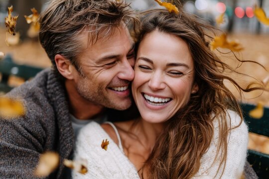 Couple shares a joyful moment surrounded by autumn leaves in a park
