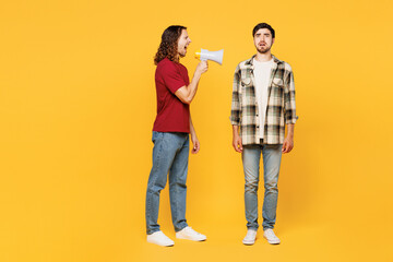 Full body young mad shocked two friends buddies men wear casual clothes together hold megaphone...