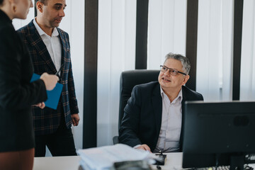 Business people in an office setting collaborating on a project, featuring a leader and team...