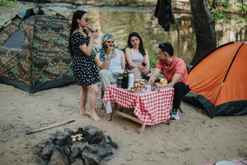 A scenic outdoor camping setting with a group of friends enjoying food and drinks beside tents.