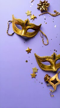 Golden decorative masks and noisemaker with stars and beads on a violet background for celebrating a spring festival.