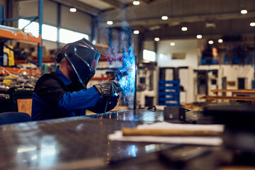Industrial Worker Welding Metal in a Factory Setting with Professional Equipment