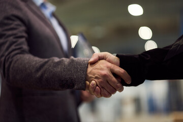 Close-Up of Two People Shaking Hands in a Professional Setting