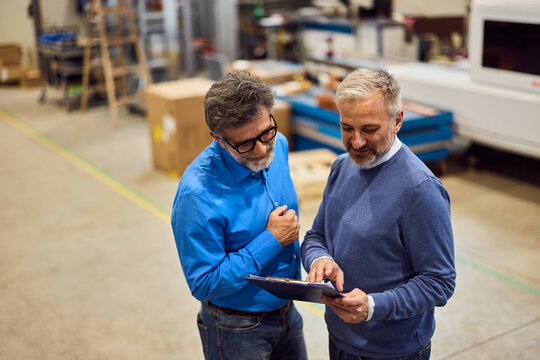 Colleagues Discussing Work Insights in a Manufacturing Facility Environment