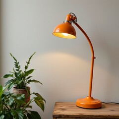 Orange Metal Desk Lamp with Plant on Wooden Table