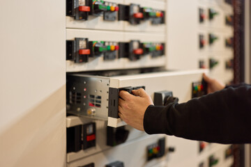 Technician Operating Electrical Control Panel with Focus on Details and Equipment