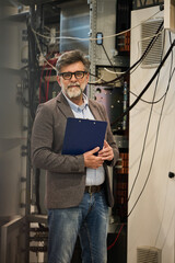 Professional Technician Holding a Clipboard in a Server Room Setting
