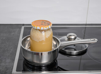 Real bee honey heated in warm water in a pot