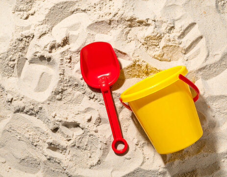 Beach Toy Flat Lay: Shovel & Bucket on White Sand. Summer Vacation Fun, Kids Play, Tropical Holiday, Seaside Recreation, Copy Space

