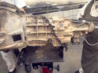 A team of expert technicians is performing maintenance on a complex car transmission system. 