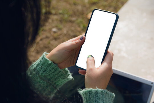 female hands using a phone with a blank screen, top view
