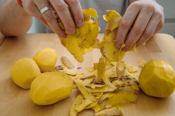 Potato peels held in hands close up, isolated organic waste