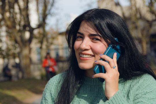 young Venezuelan woman outdoors on a phone call
