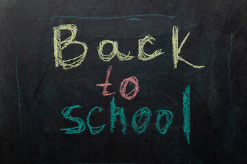 Bold, colorful chalk writing on a blackboard announces the return to school. Students eagerly...