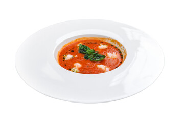 Freshly prepared tomato soup with shrimps, basil and creamy toppings served in a white bowl....