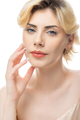 Naklejka premium A young blonde girl with clear skin in a satin top. Beauty portrait of a woman on a white background in the studio.