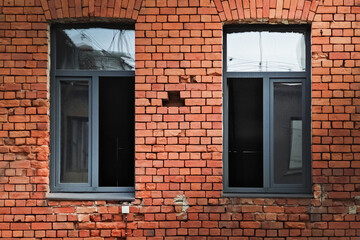 Windows on a brick wall showcasing urban architecture and textures in a modern setting