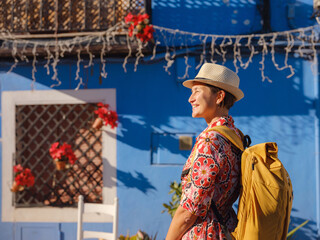 Woman in dress strolls through colorful streets of Spanish coastal town of La Vila Joiosa or Villajoyosa. sunny winter atmosphere highlights charm of Mediterranean architecture and quiet seaside life