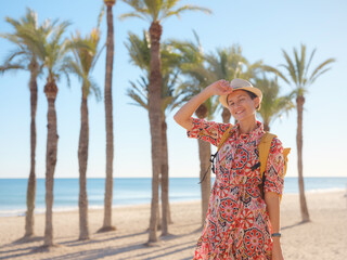 Woman in dress strolls through colorful streets of Spanish coastal town of La Vila Joiosa or Villajoyosa. sunny winter atmosphere highlights charm of Mediterranean architecture and quiet seaside life