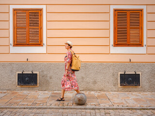 Beautiful woman walking of Varazdin streets during summer day in old, historical city center. Tourist exploring the beautiful streets, experiencing relaxed and cultural vibe of this Croatian city.
