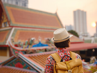 Woman Exploring Colorful Streets Near Buddhist Temples in Bangkok. Female traveler strolling through charming streets of Bangkok, surrounded by traditional architecture and beautiful Buddhist temples.