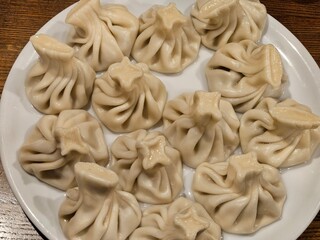 A plate of dumplings with a star on top. The dumplings are white and arranged in a circle